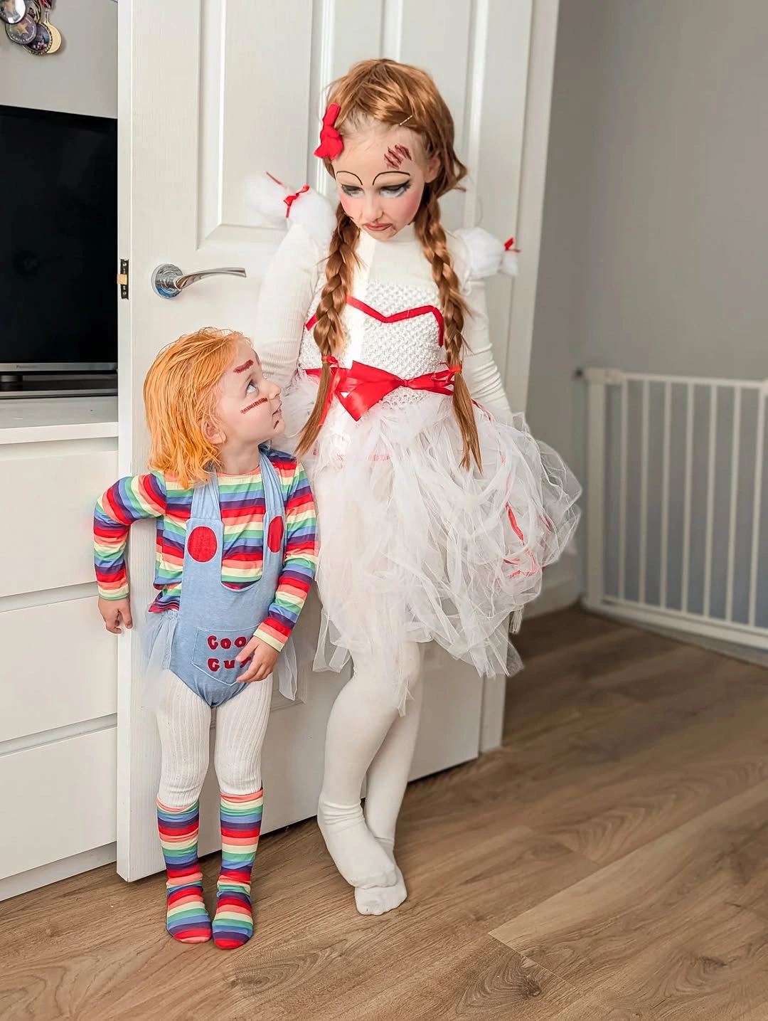 Kids striped doll costume paired with white ruffled dress and red ribbon accents