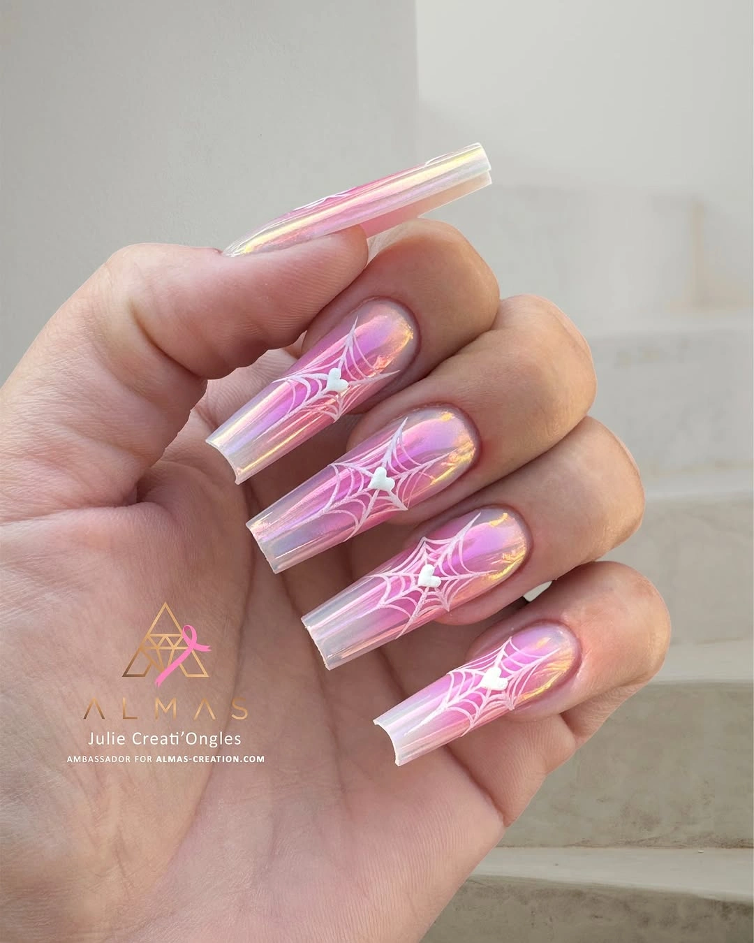 Long transparent pink nails with iridescent spiderweb linework