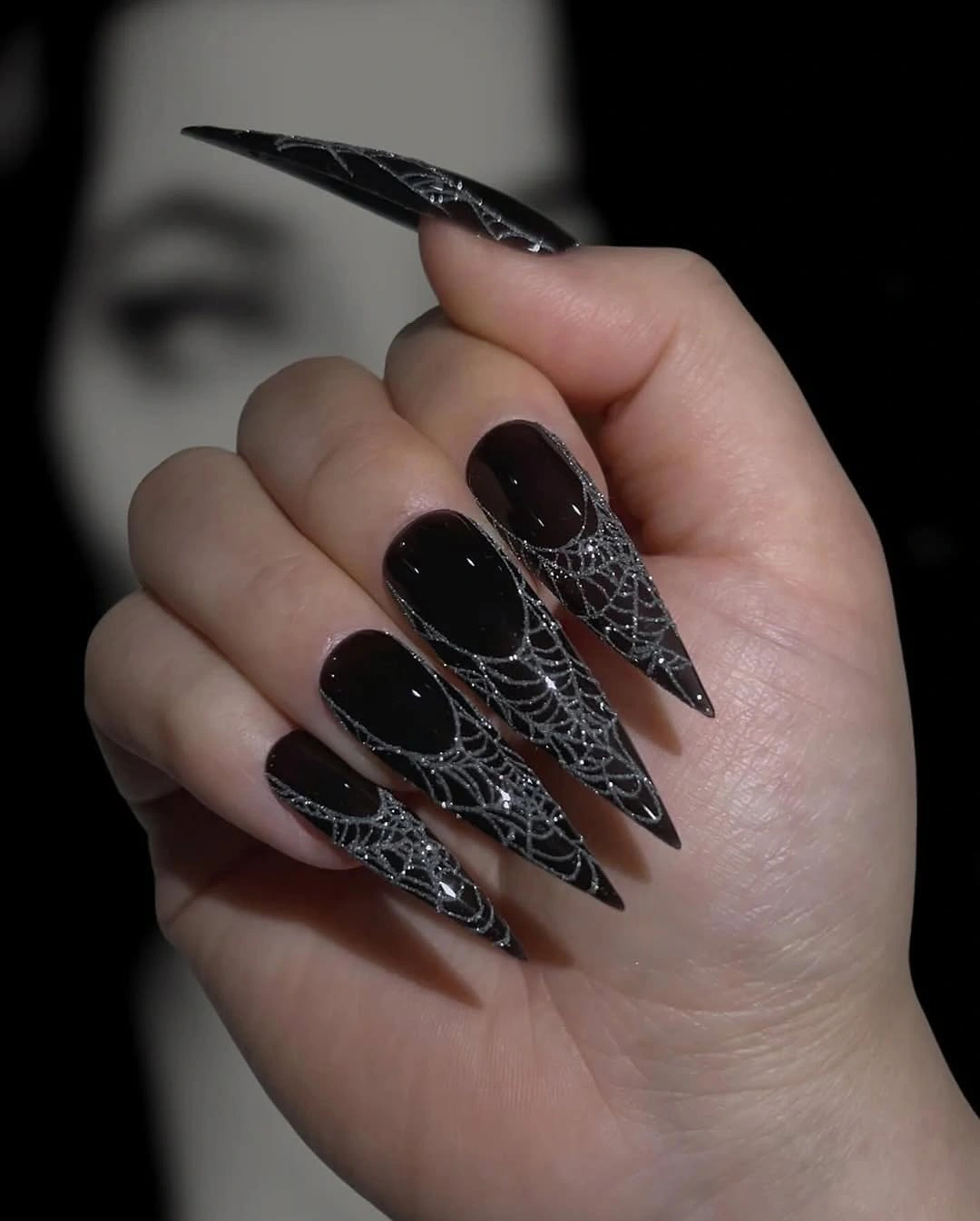 Long black stiletto nails with silver spiderweb texture