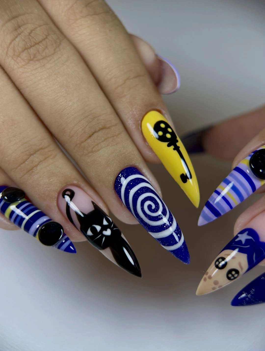 Cobalt blue almond nails with spirals ghosts and graphic accents