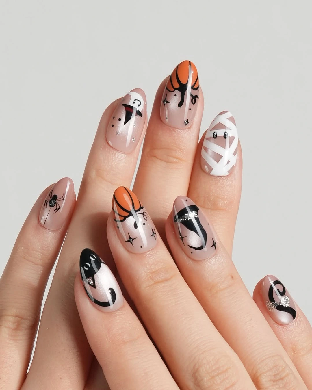 Short almond nails with black white orange and pink Halloween symbols
