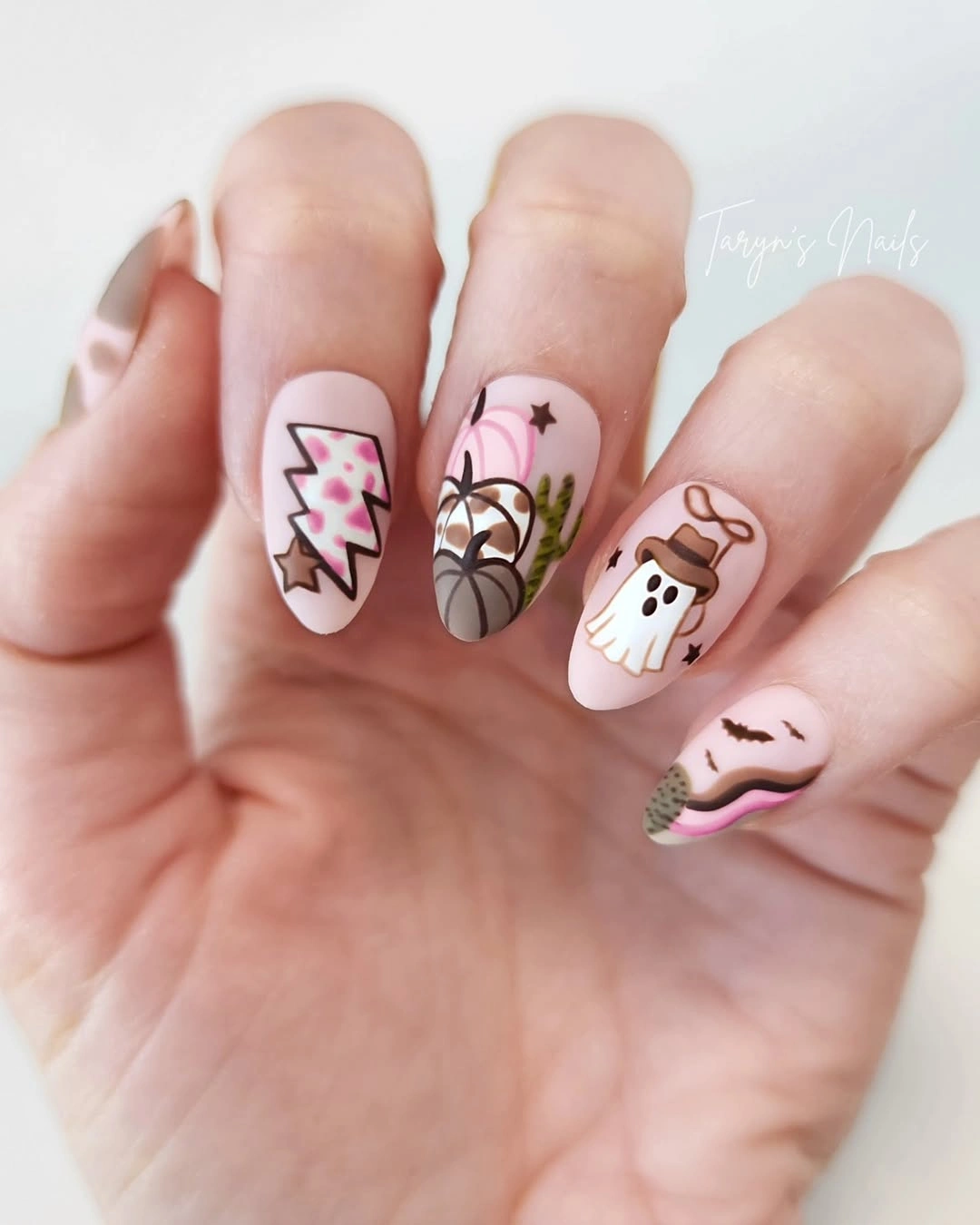 Short rounded nails with tiny ghosts stars pumpkins and zigzags