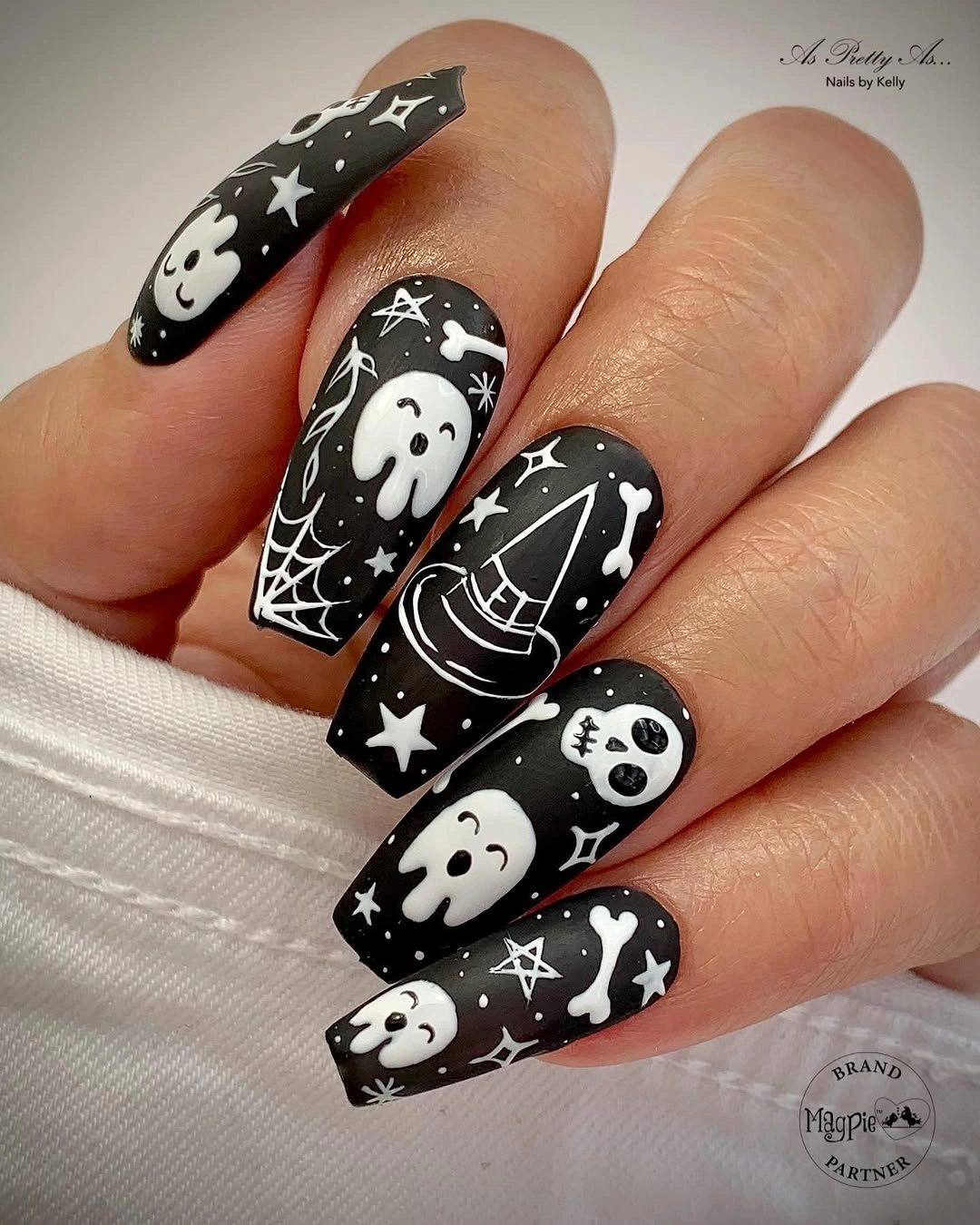 Long black almond nails with white ghosts stars and celestial marks