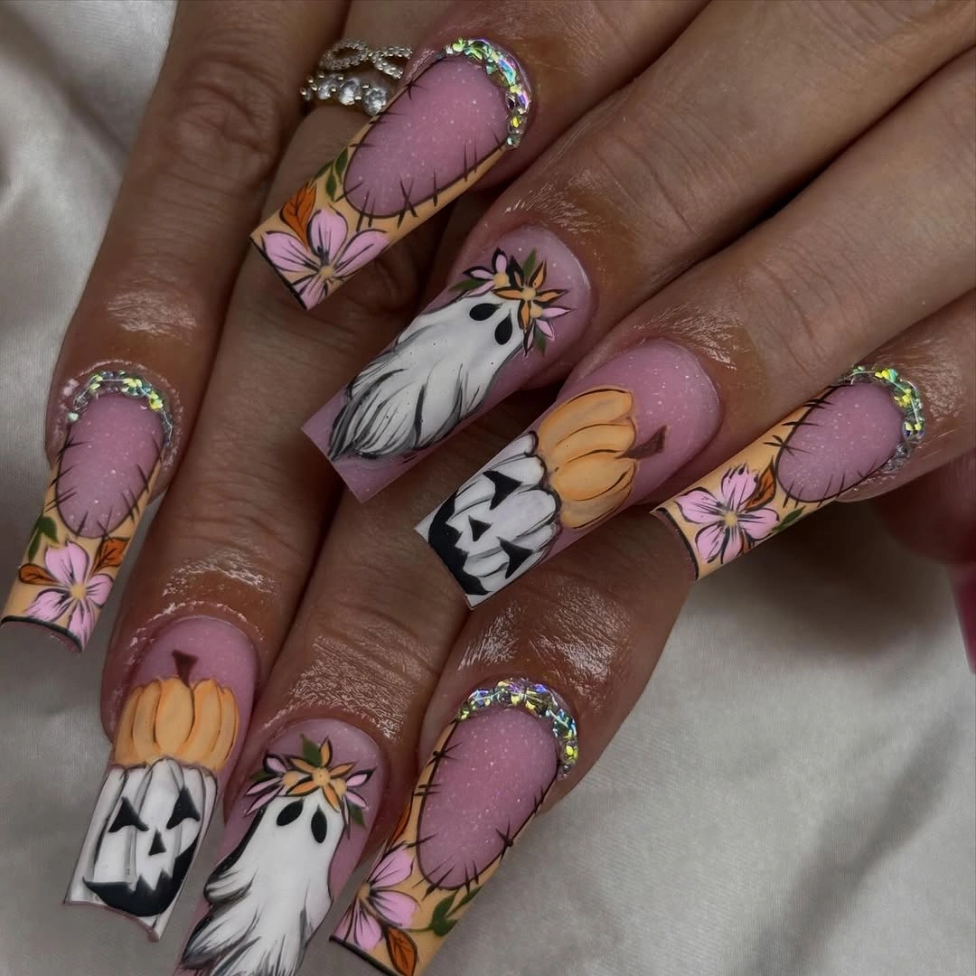 Long pink almond nails with ghosts pumpkins and layered Halloween art