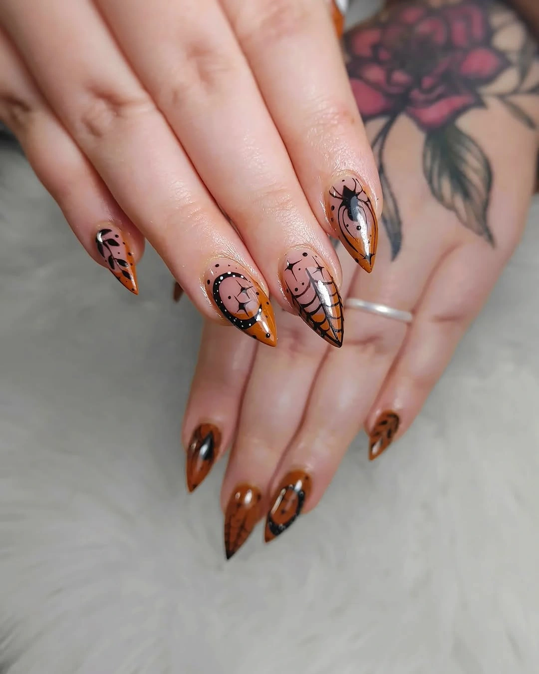 Warm brown almond nails with orange and black Halloween details