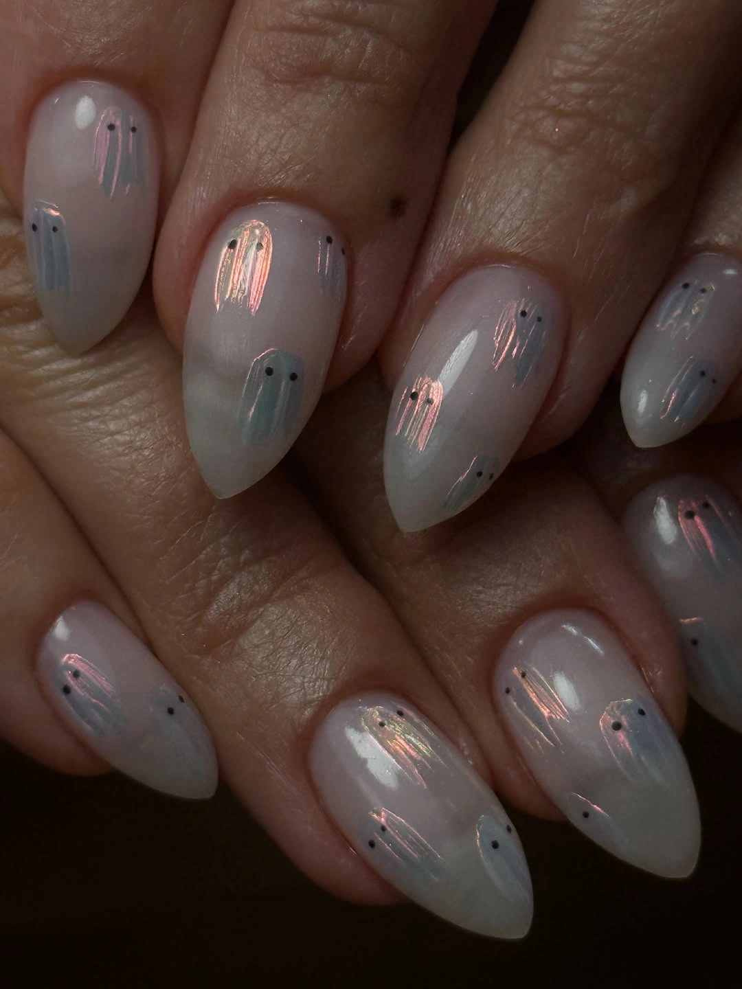 Sheer gray almond nails with subtle iridescent Halloween details