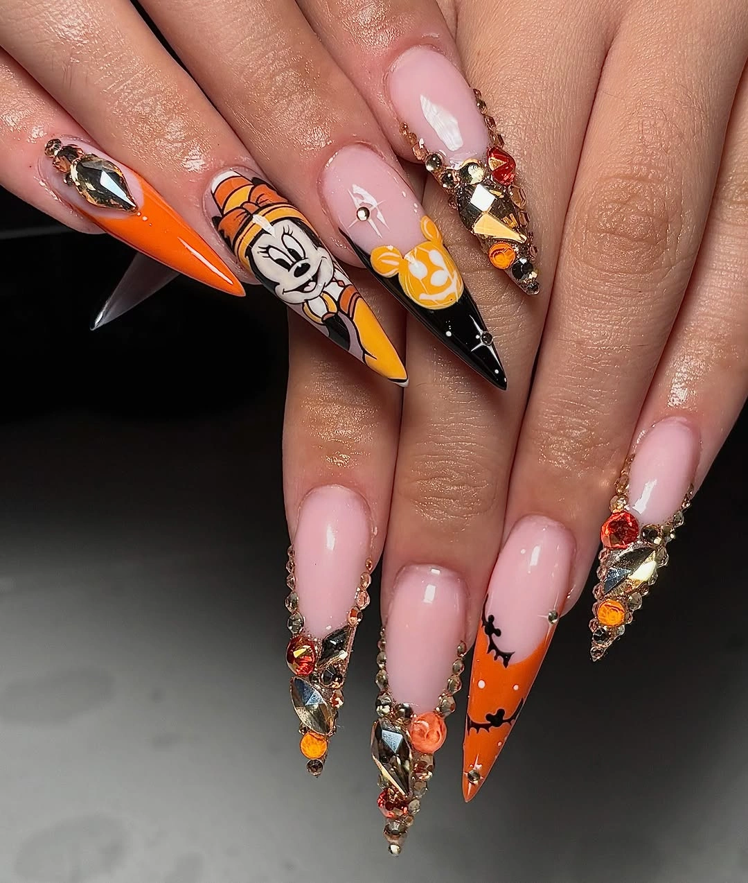 Very long stiletto nails with pink orange black graphics and crystals