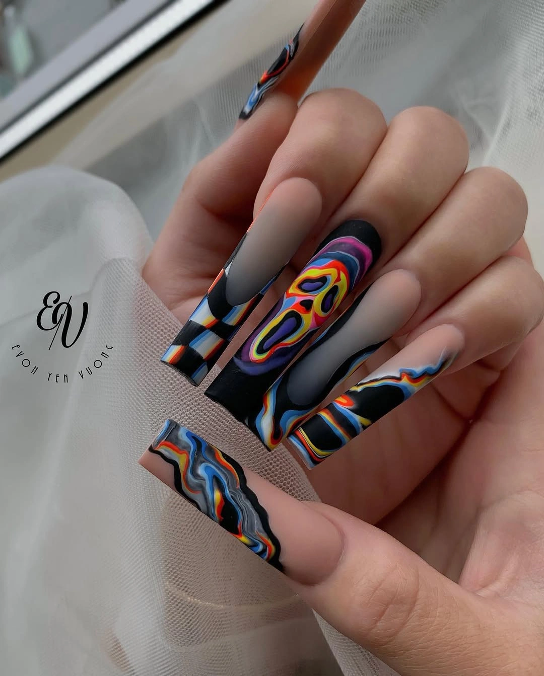 Long coffin nails with neon orange blue and graphic swirls