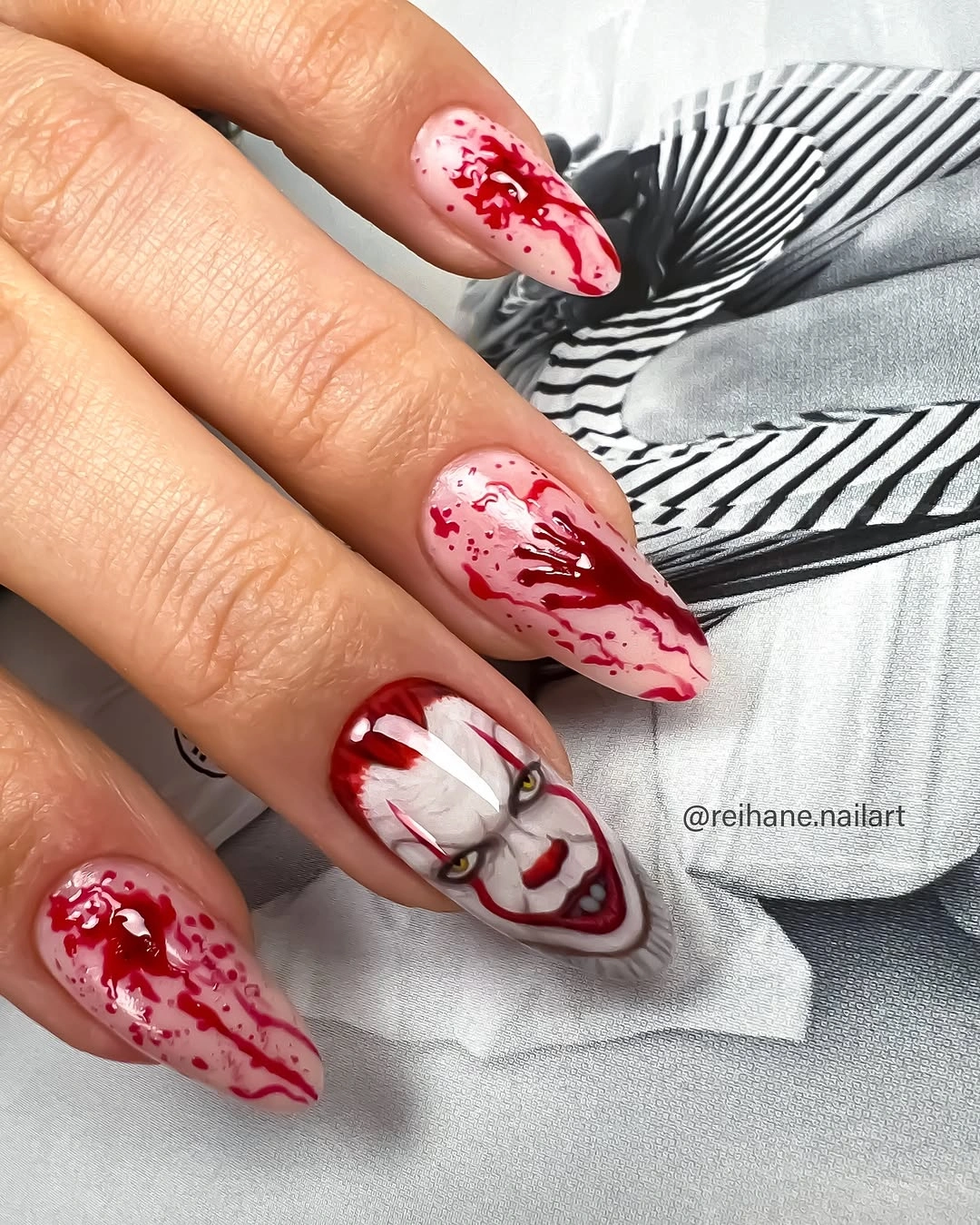 White stiletto nails with red splatter and drip details