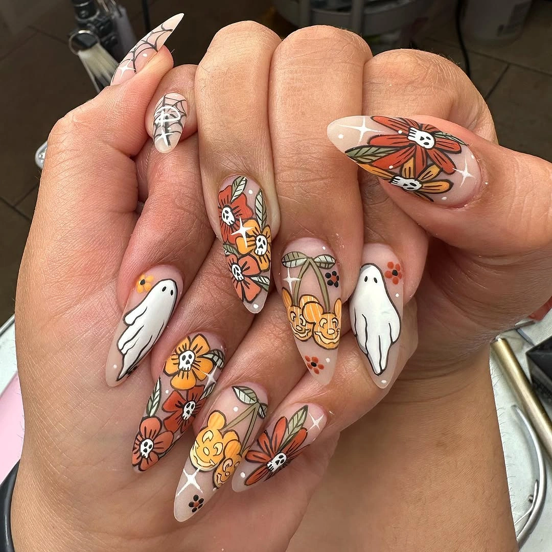 Pale stiletto nails with black spiderwebs and ghost details