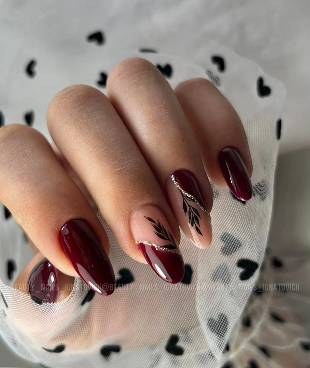 Maroon almond nails with nude botanical accent nails