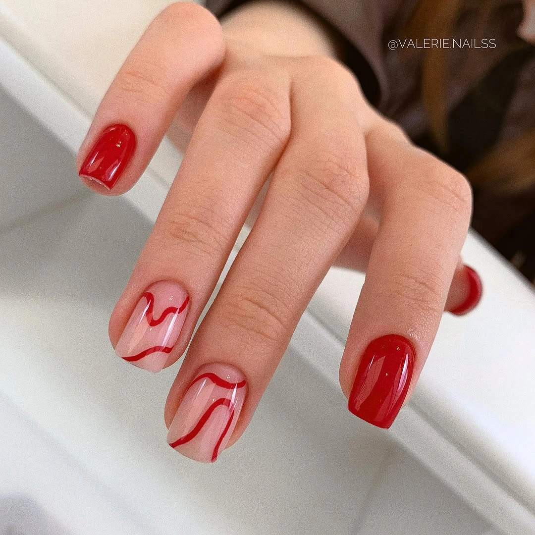 Bright red nails with abstract red waves over sheer pink base