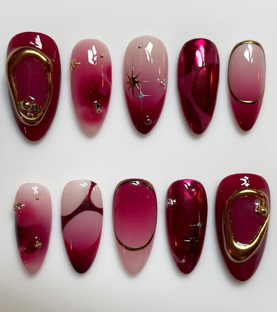 Maroon ombre and metallic nail designs with gold framed accents