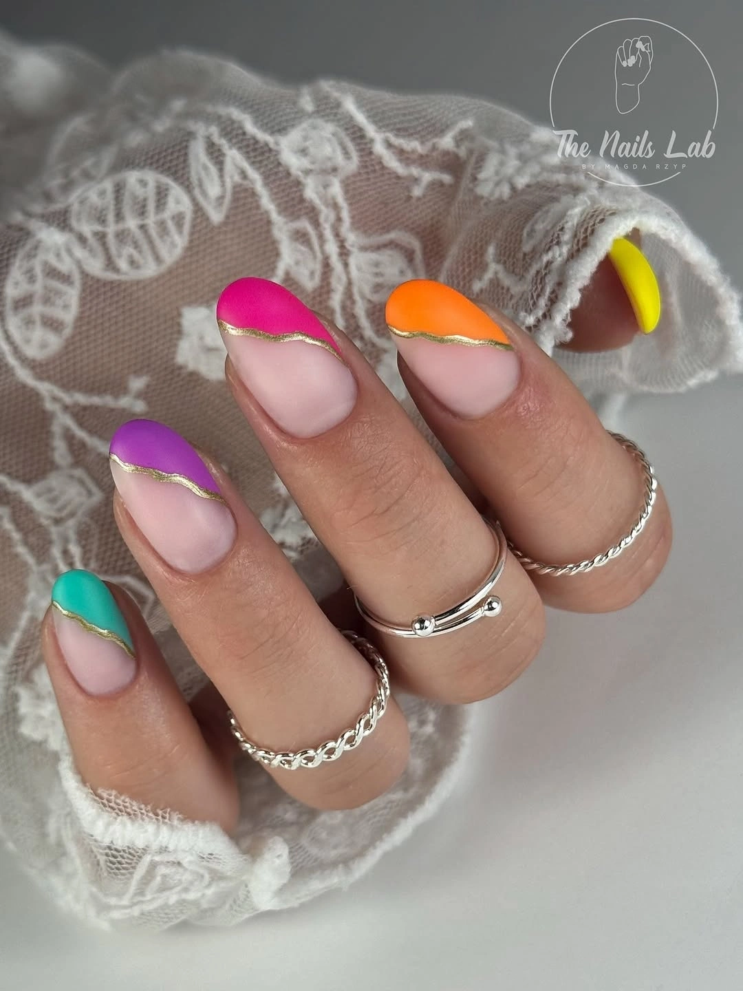 Sheer nude nails with bright French arcs and gold lines