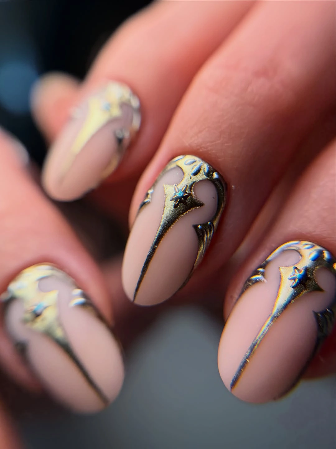 Nude almond nails with metallic stars and chrome line details