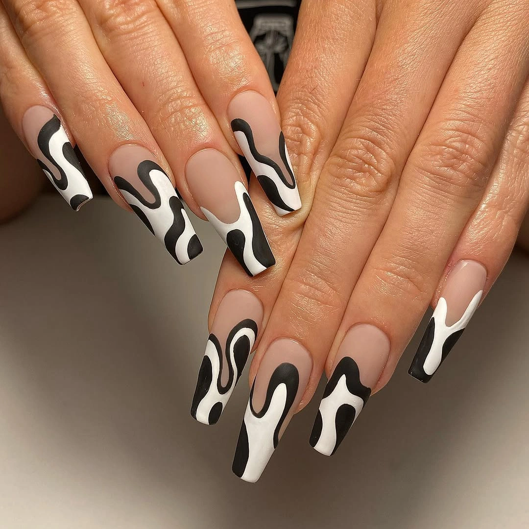 Long nude almond nails with bold black and white waves
