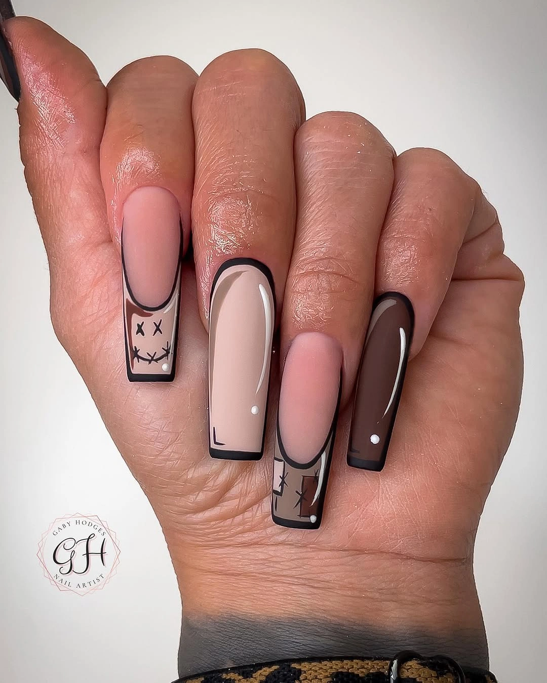 Blush square nails with black outlines and dark mauve accents