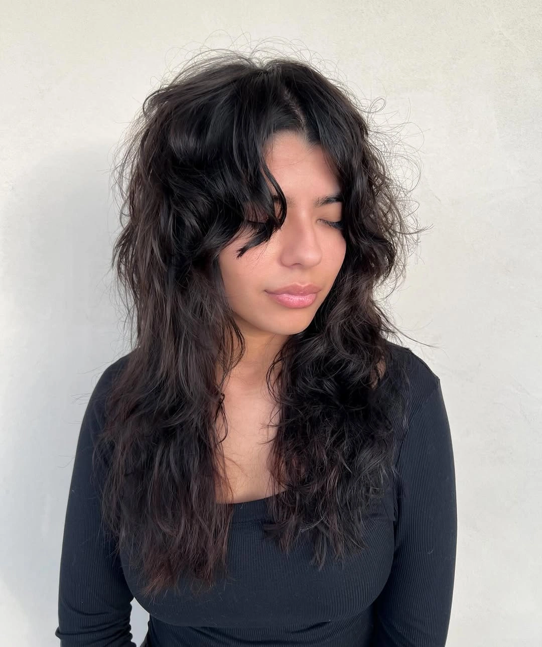 Dark shaggy middle part waves with uneven textured ends