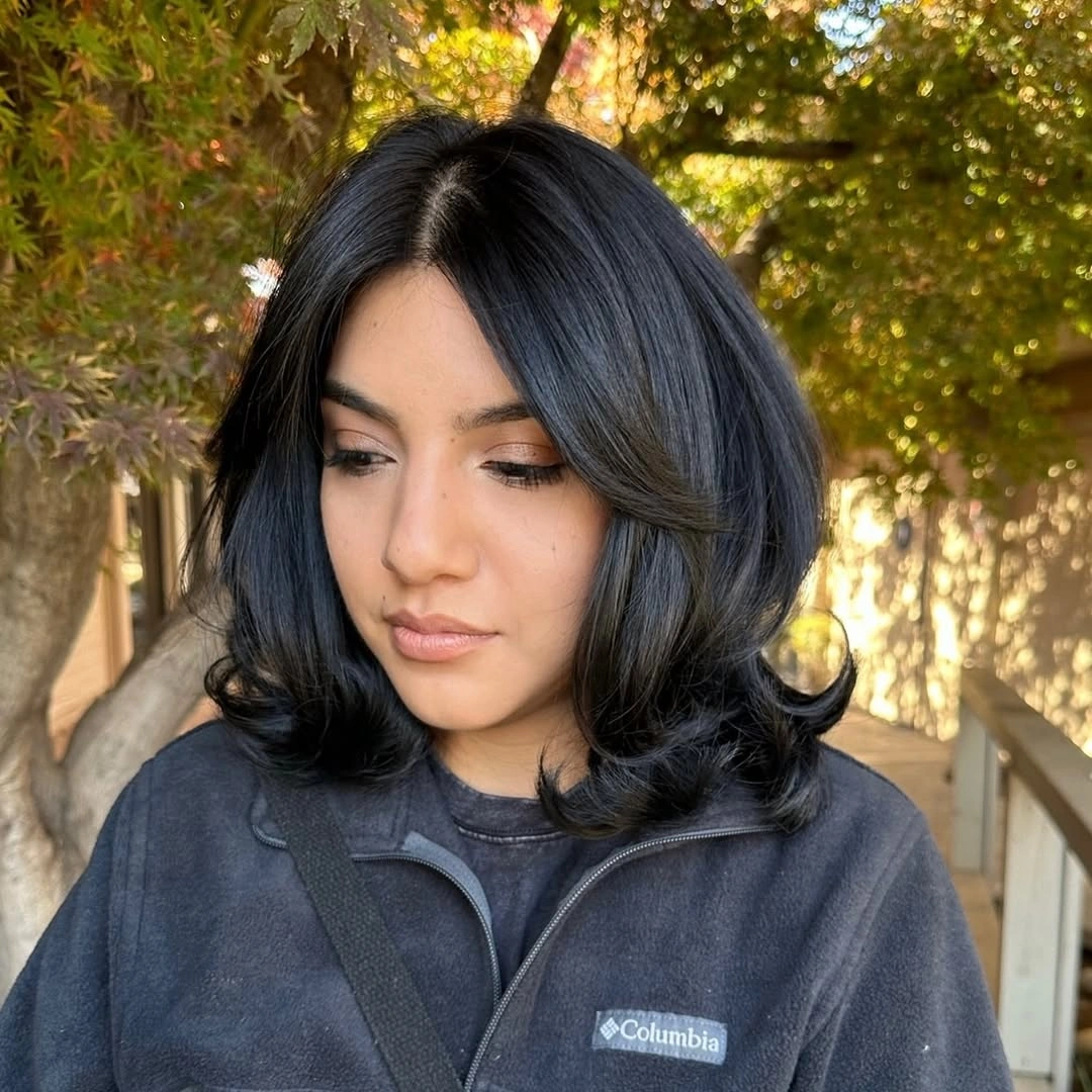 Rounded black middle part bob with softly tucked ends