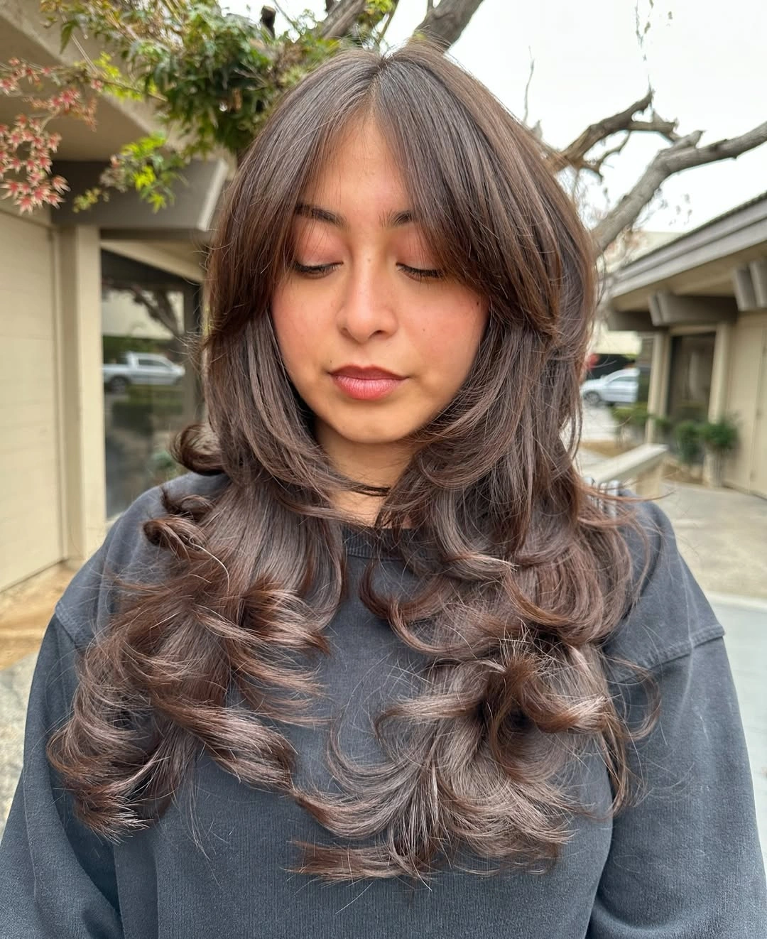 Medium brown middle part hair with large rounded curls