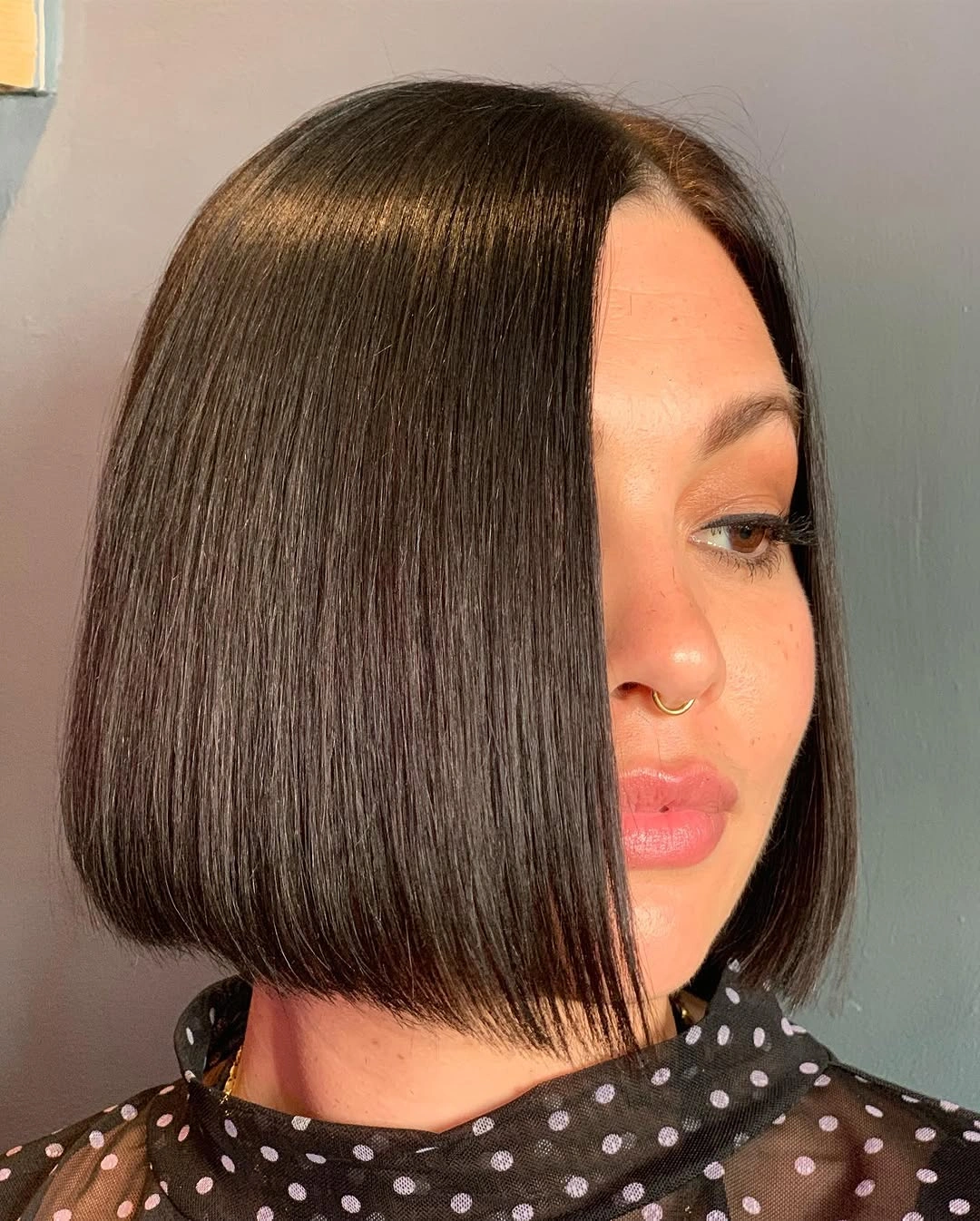 Side profile of sleek tucked middle part bob at jaw length