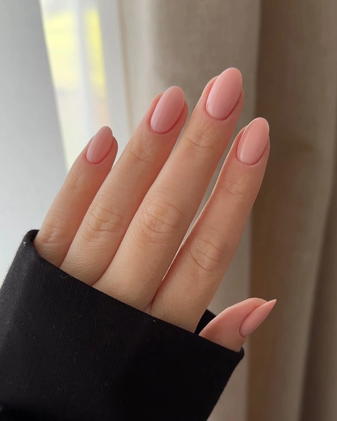 Medium almond nails in a warm coral nude shade