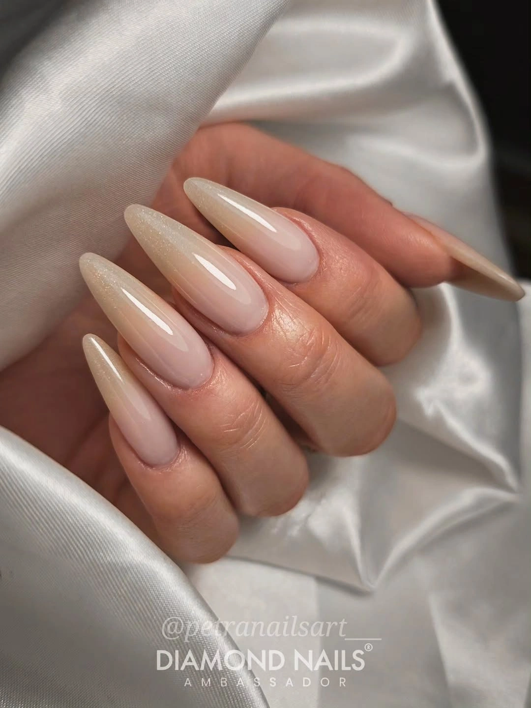 Long milky nude almond nails with a soft light-catching accent