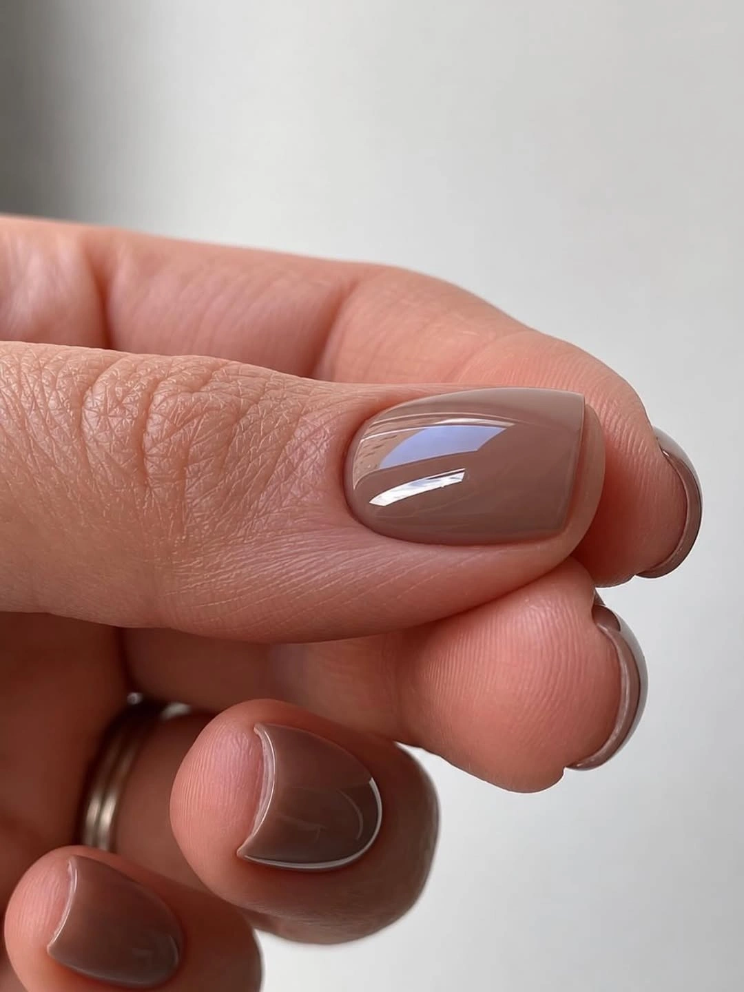 Short taupe nude nails with one fine pale curved outline