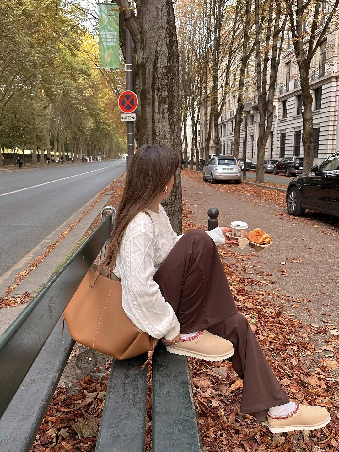 White cable sweater with brown trousers tan tote and slip-on shoes