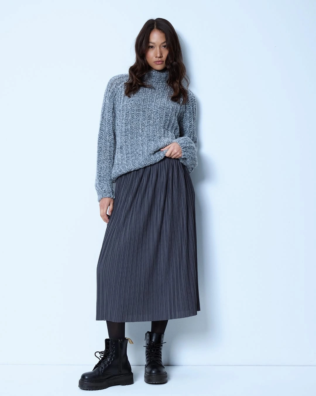 Gray chunky turtleneck with pleated midi skirt and black combat boots