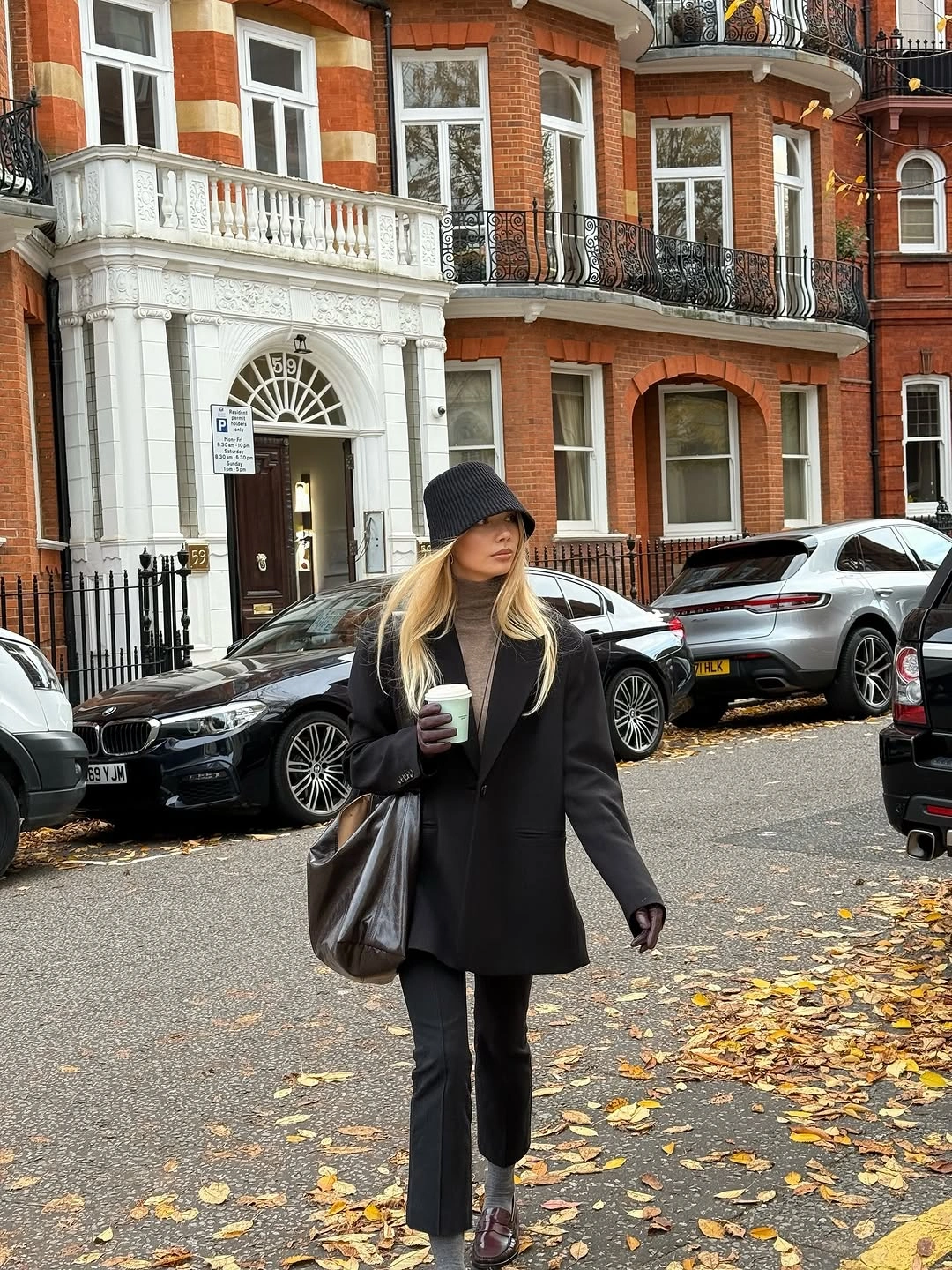 Black blazer with gray turtleneck cropped trousers burgundy loafers and bucket hat