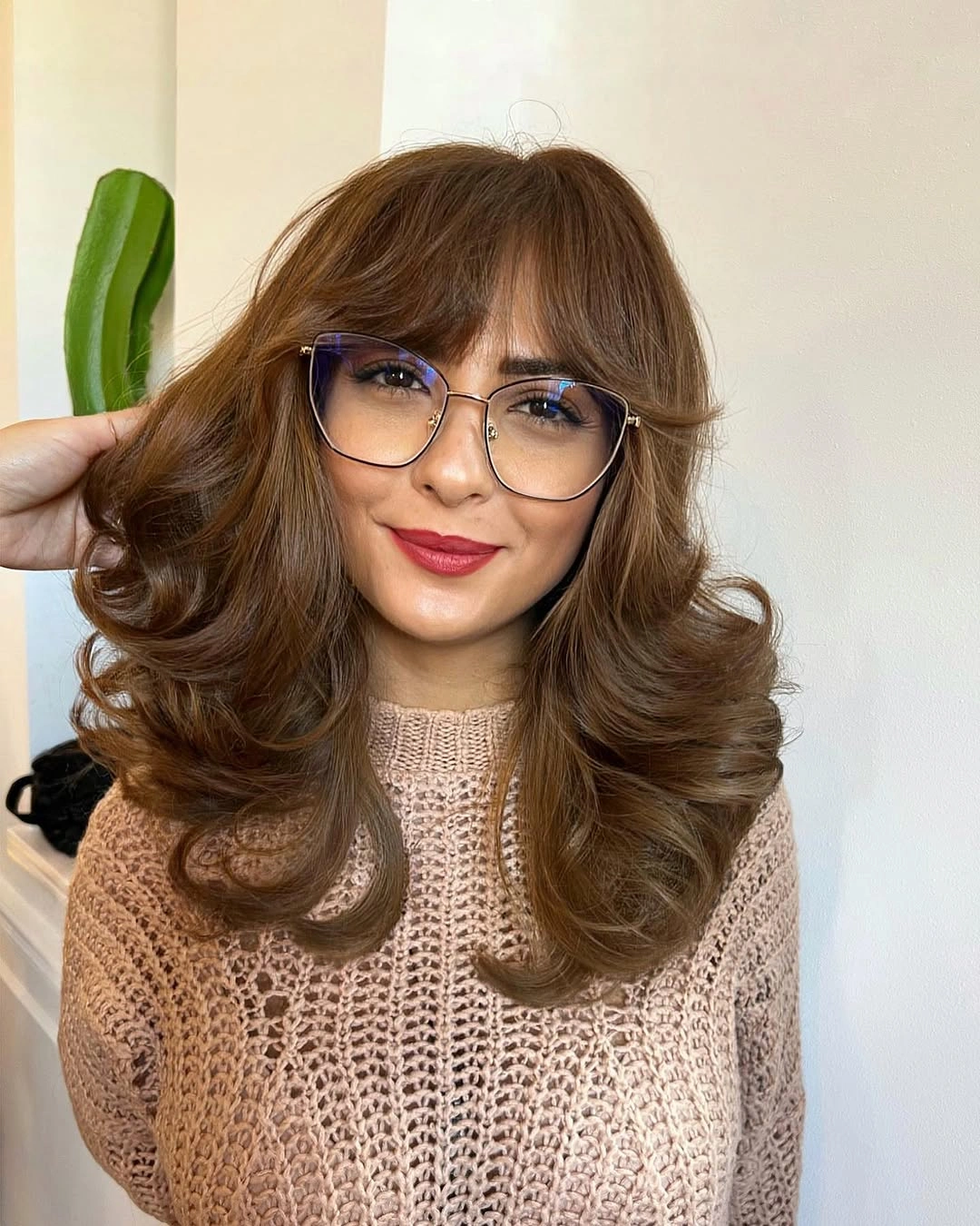 Warm medium-brown hair with curtain fringe and large brushed-out curls