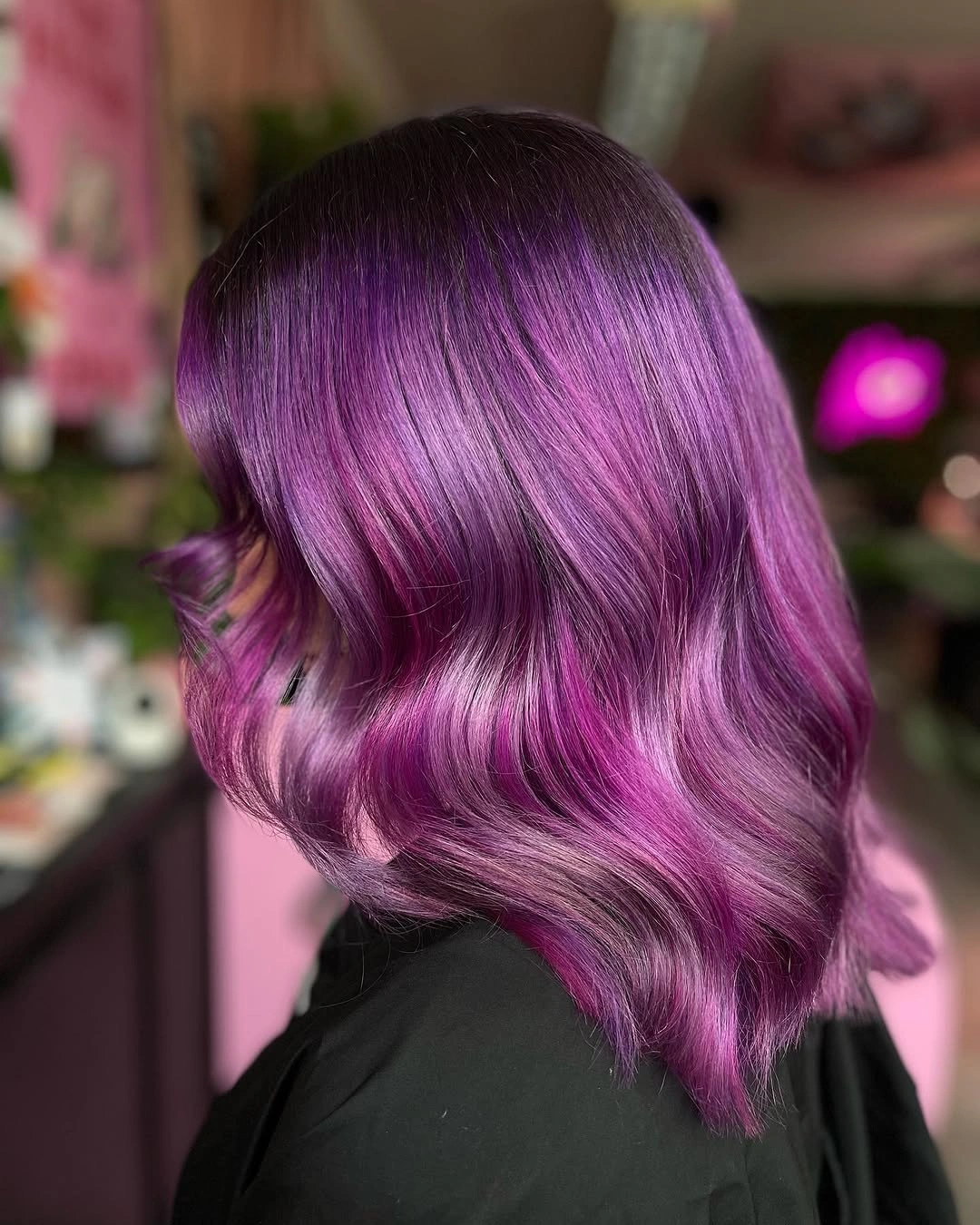 Shoulder-length deep purple waves with brighter magenta reflection through the lengths