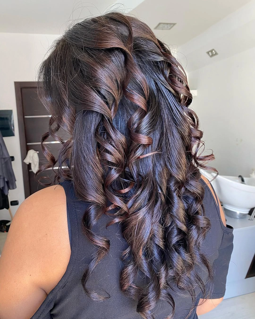 Defined dark chocolate ringlets with subtle warm brown threads through the curls