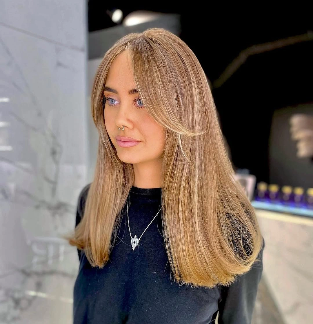 Long warm beige-blonde hair with slightly deeper root and softly curled-under ends