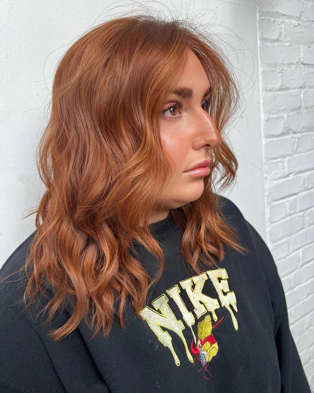 Shoulder-length warm copper waves with side part and relaxed uneven texture