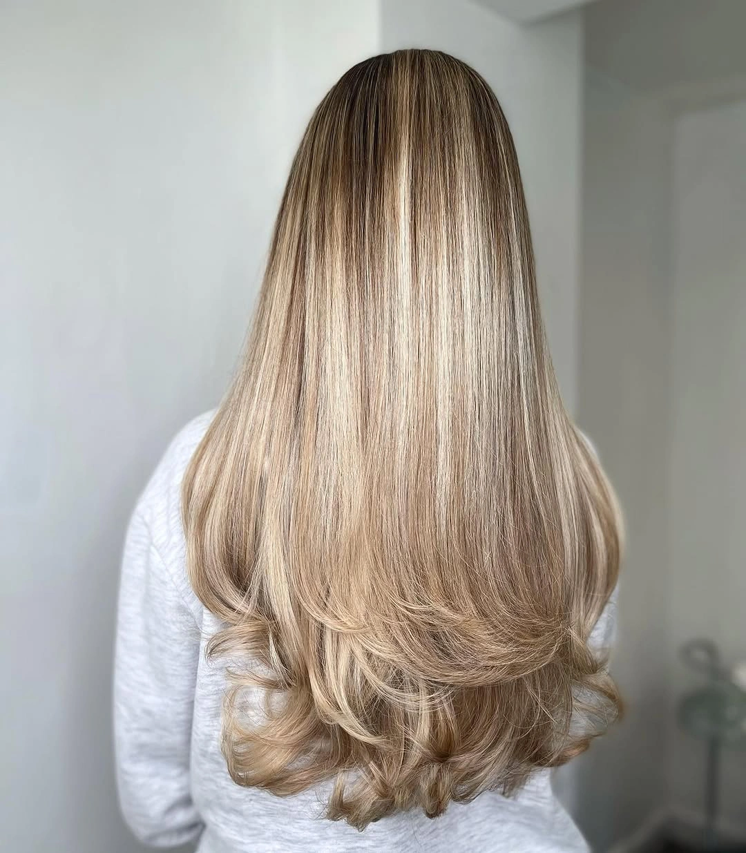 Very long beige-blonde hair with fine neutral ribbons and softly curled ends