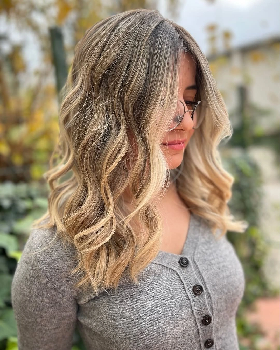 Soft brown-rooted waves with creamy blonde face-framing sections