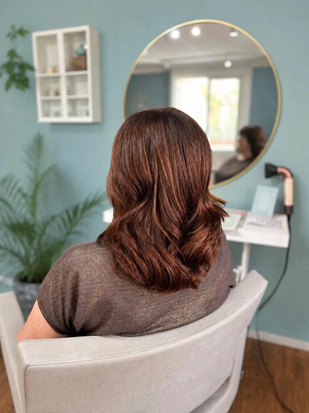 Medium-long chestnut hair with soft waves and rounded curved ends