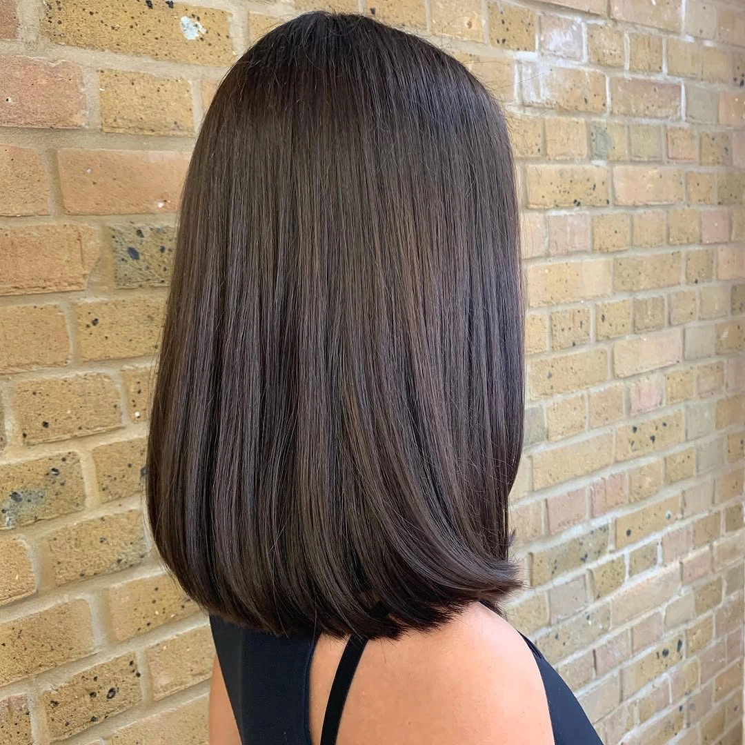 Smooth dark brown angled bob with precise curved perimeter and tucked ends