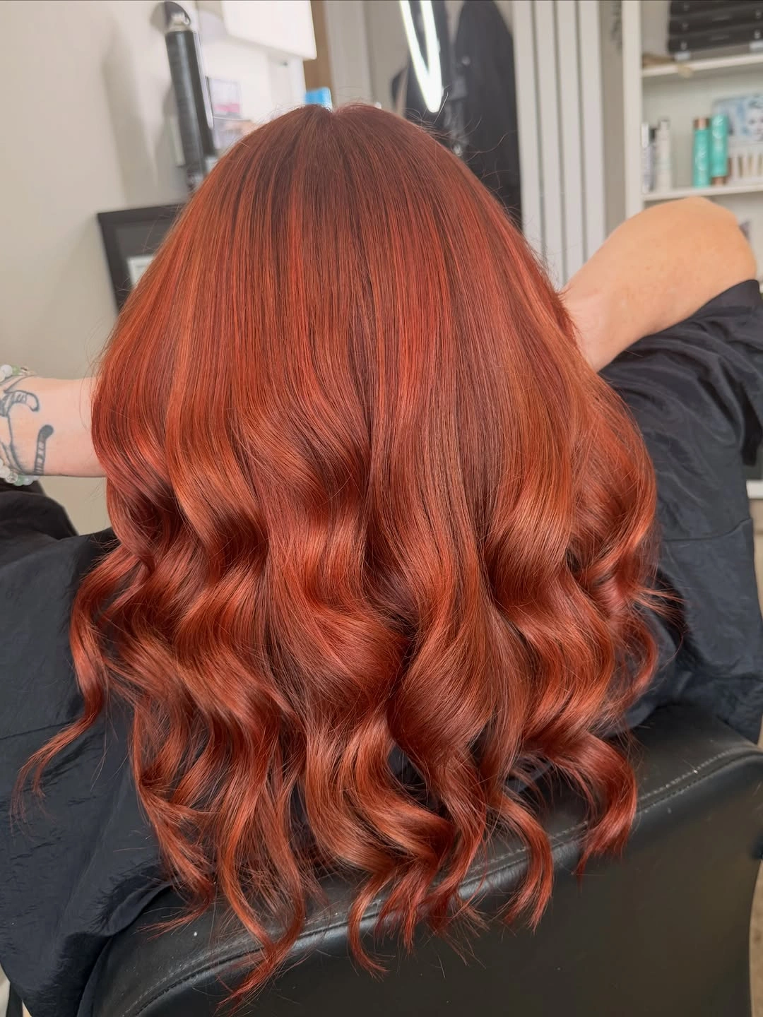 Long saturated copper-red hair with broad glossy S-waves and flowing layers