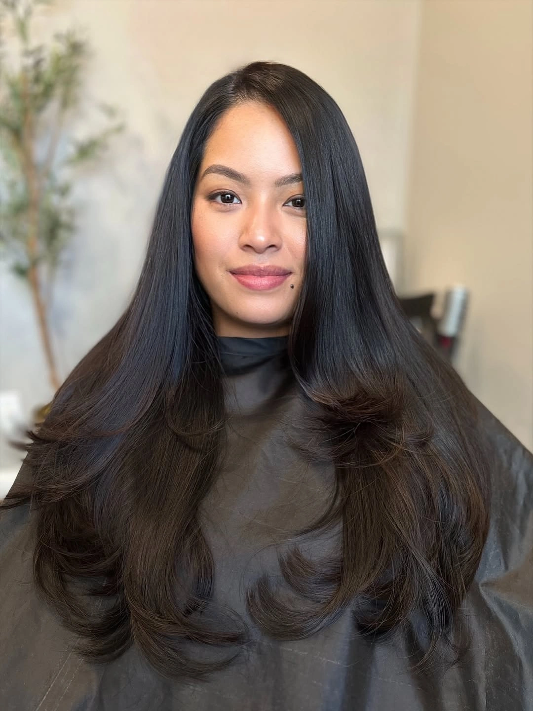 Very long near-black hair with smooth middle part and large curled ends