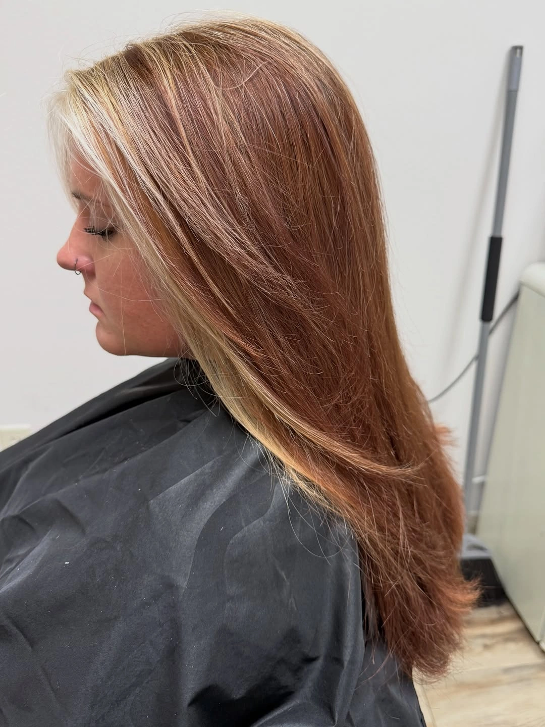 Warm light-brown layered hair with a pale front section and curled ends