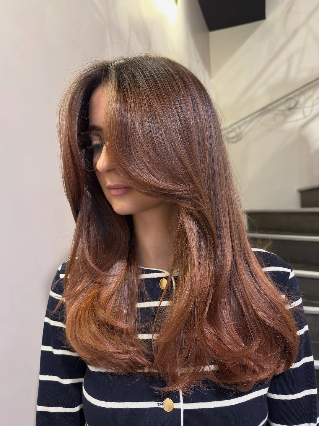 Long chestnut hair with deep side part and swooping face layers