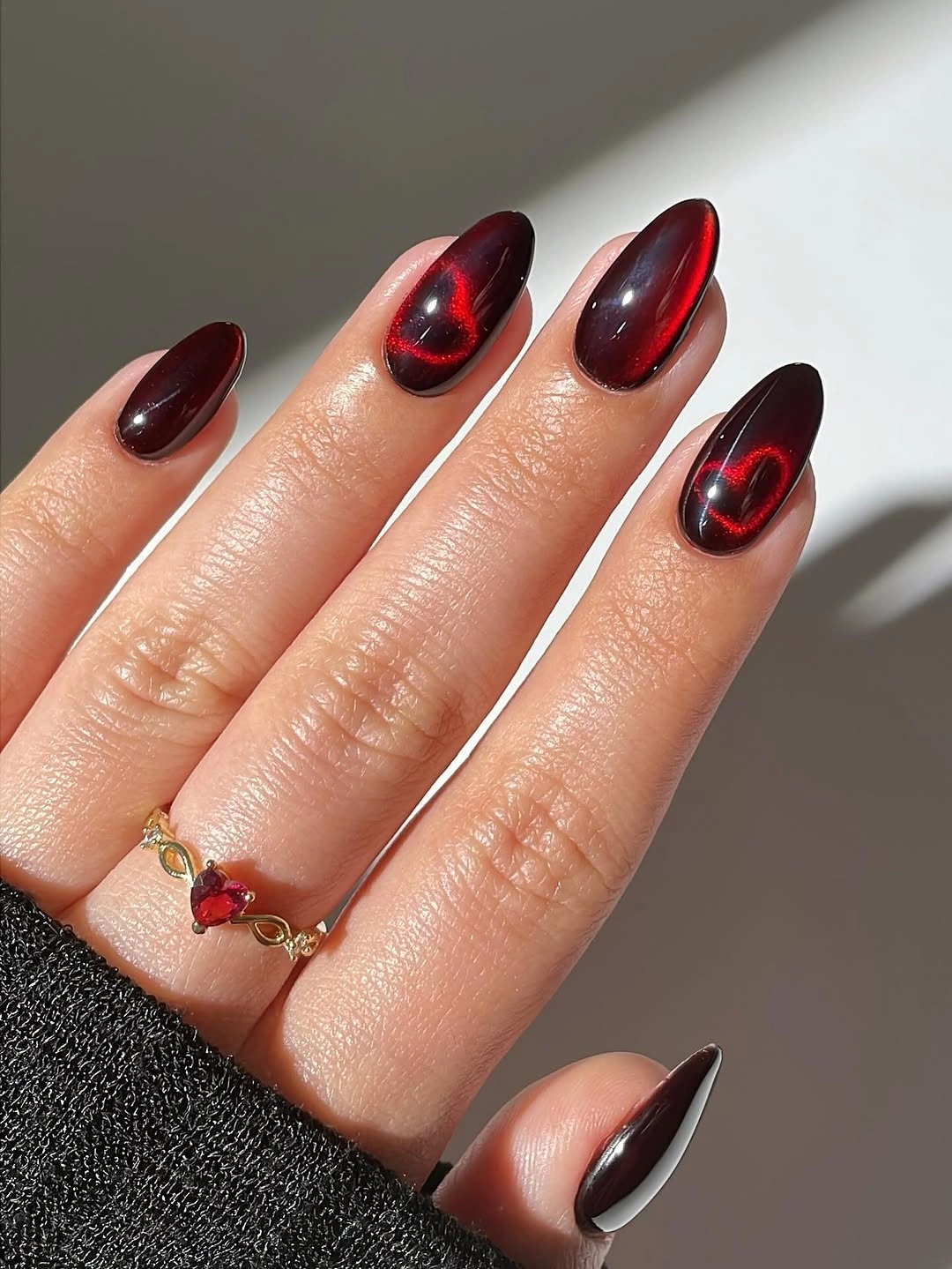 Medium almond nails with deep red black reflective color streaks