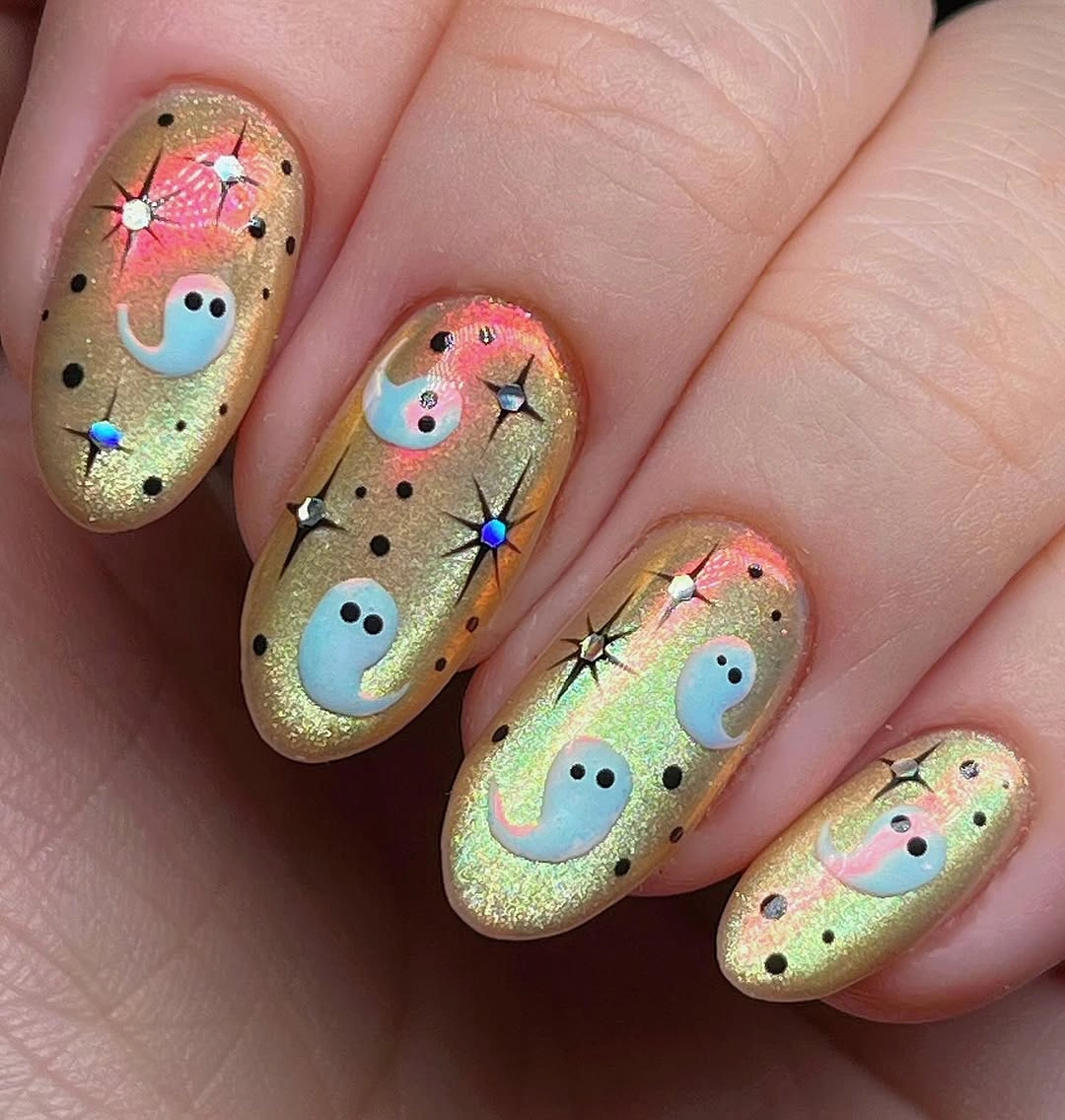 Olive gold almond nails with pastel ghosts black dots and stars