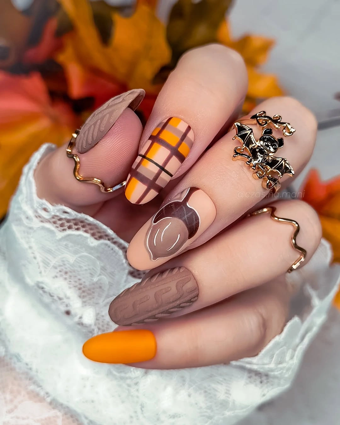 Warm nude nails with orange plaid leaf art and orange accent