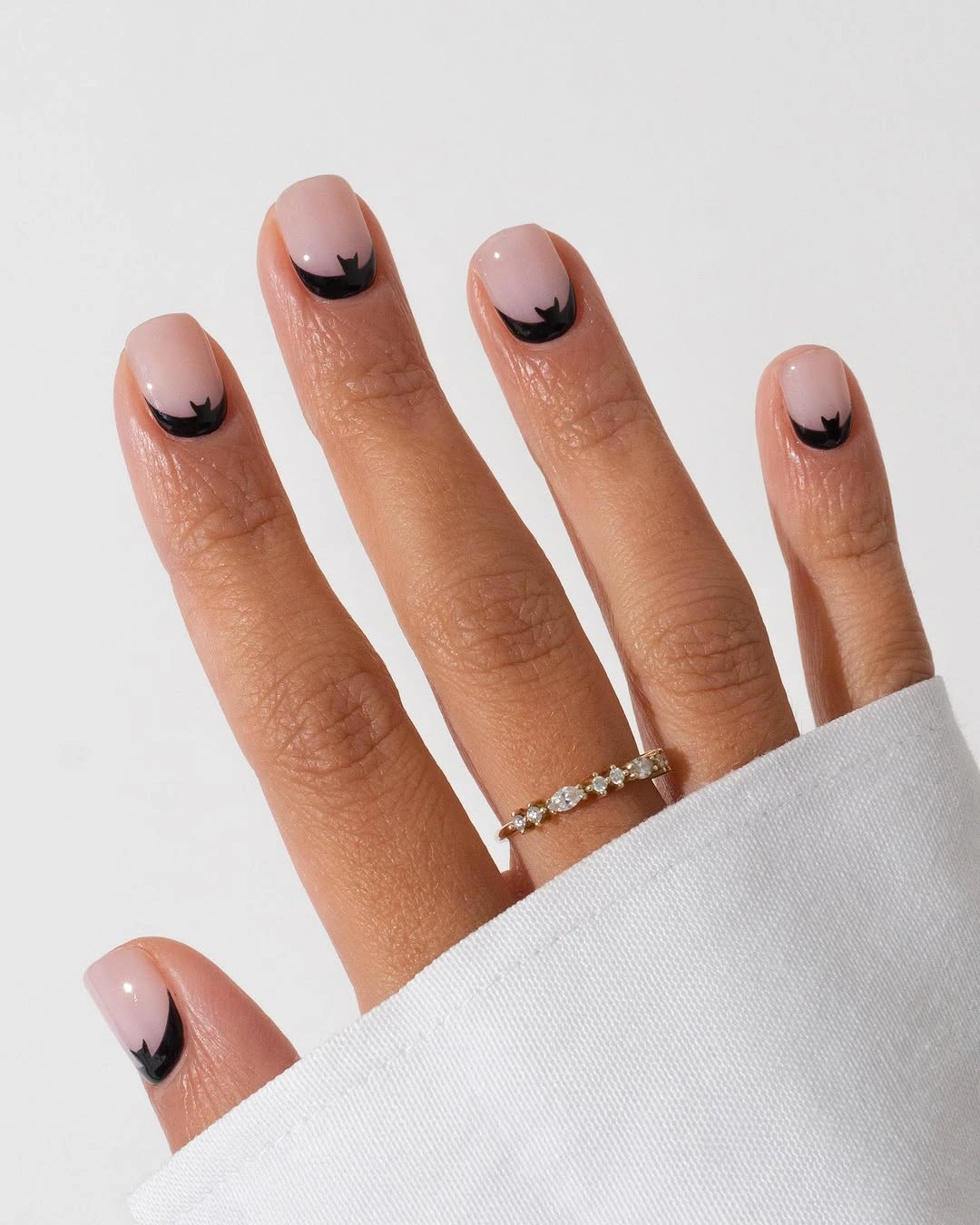 Short nude almond nails with tiny black curved tip accents