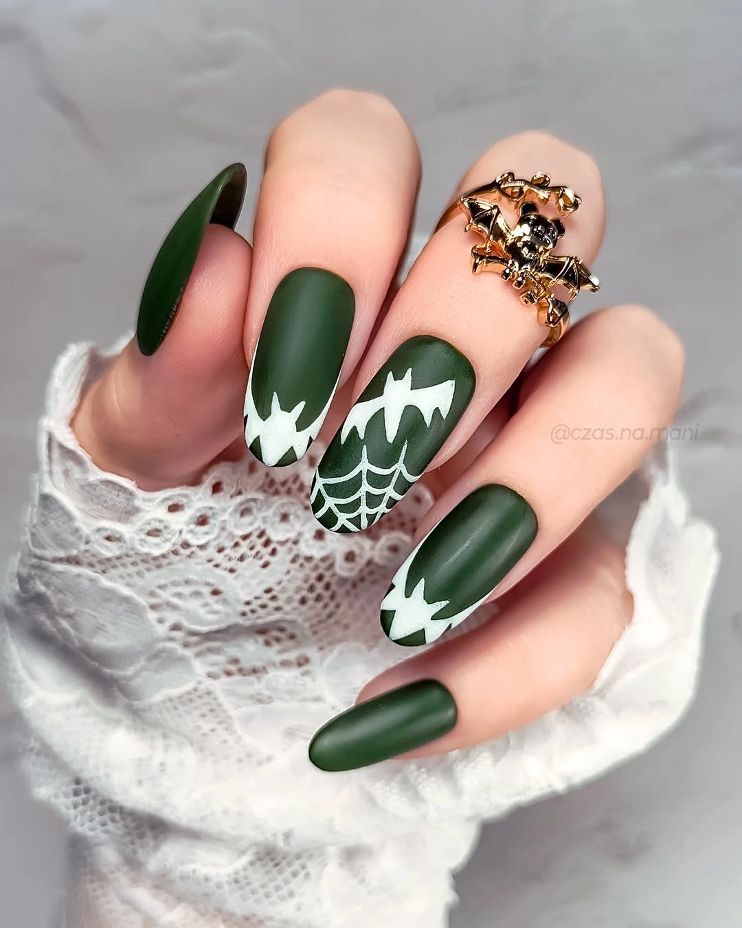 Long matte forest green nails with white spiderweb and graphic accents