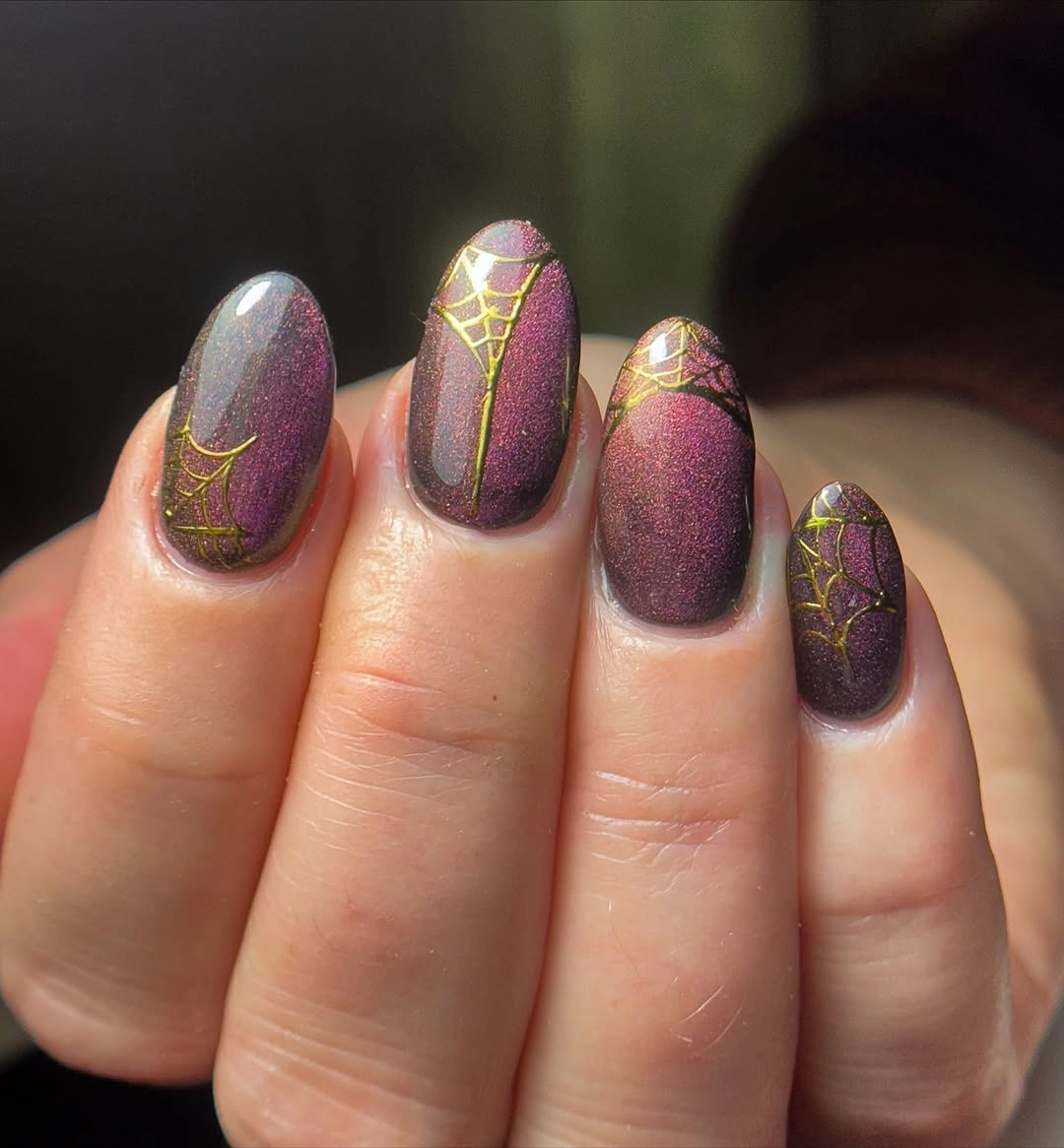 Muted plum almond nails with fine gold web inspired line details